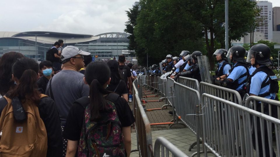 Demonstrators file past a line of riot police behind the Legislative Council on Wednesday. Photo by Stuart White.