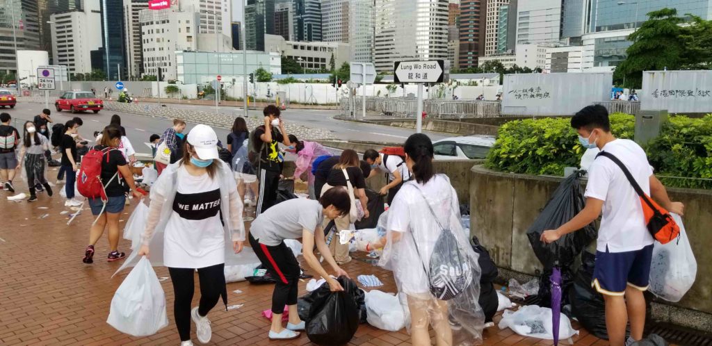 Protesters cleaning up trash left over from yesterday's protest against the extradition bill. Photo by Vicky Wong.