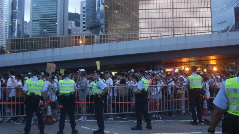 Police man a barricade as anti-extradition protesters file by on Sunday. Photo by Vicky Wong.