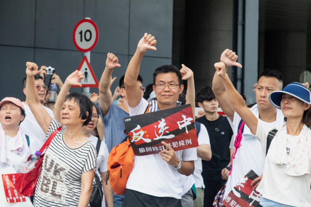 Protesters signal their opposition to the extradition bill at the massive protest today. Photo by Samantha Mei Topp.