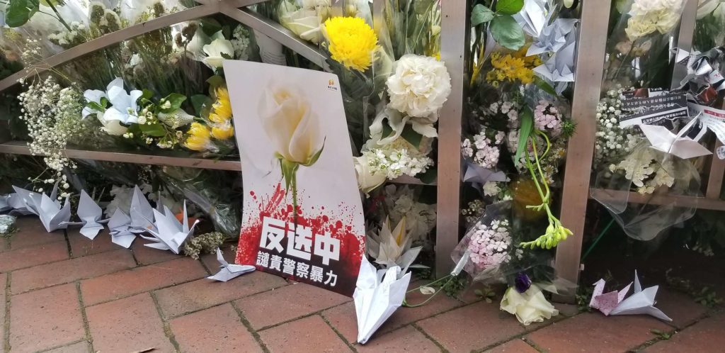 A sign reading 'XXXX' can be seen among the flowers left to honor an anti-extradition protester who fell to his death near Hong Kong's Pacific Place mall on Saturday, June 15. Photo by Vicky Wong / Coconuts Hong Kong