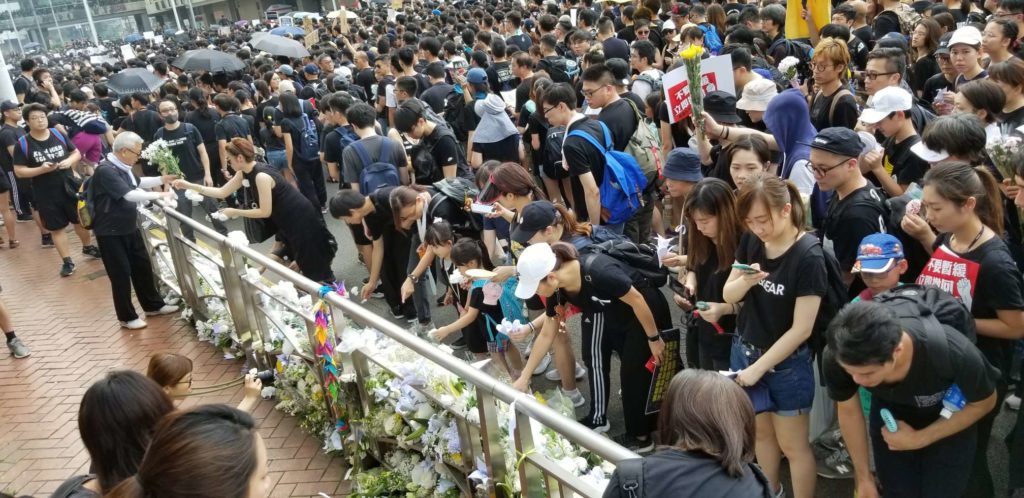 Members of a vast crowd of protesters marching against a controversial extradition bill leave flowers for a fellow protester who fell to his death on June 15. Photo by Vicky Wong/Coconuts Hong Kong