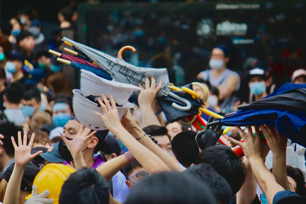 Protesters passing on umbrellas and helmets to others during a protest against a controversial extradition bill.