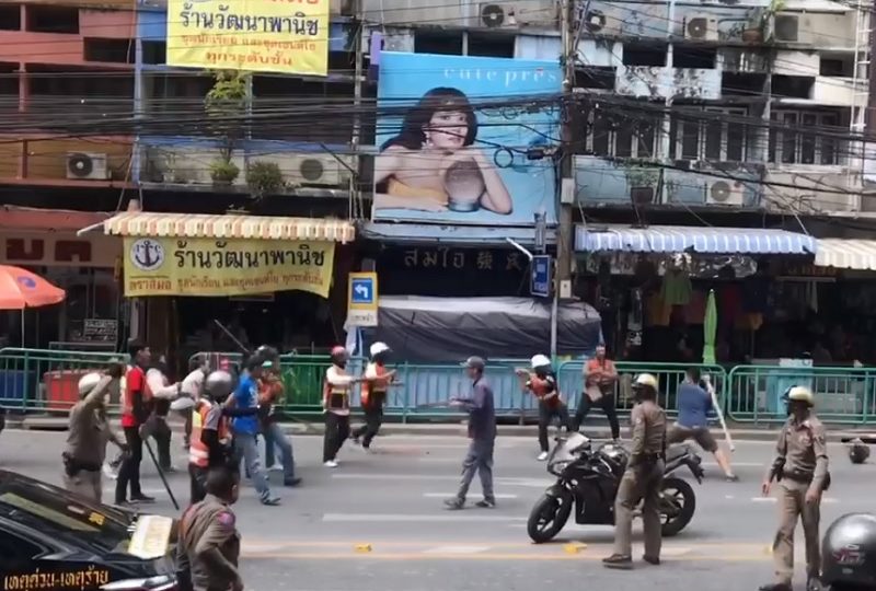 Police stand by as Saturday’s street battle rages in Udom Suk. Still image from a video posted to Facebook by user Aarise Chakonkun.