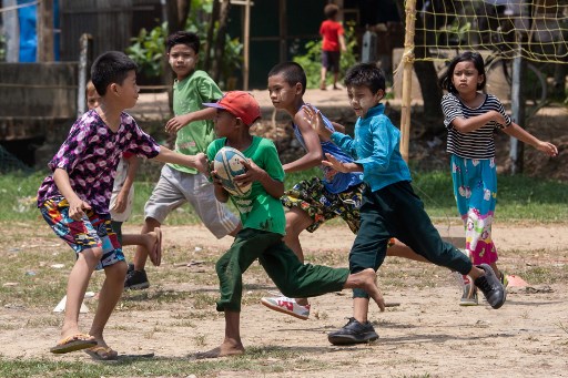 This picture taken on May 19, 2019 shows players from the Little Dragons rugby team taking part in a training session in the North Dagon township, located on the outskirts of Yangon. – Sidestepping cowpats and garbage, Myanmar’s only home-grown junior rugby side train on the outskirts of Yangon, preparing to take on children from the city’s well-heeled international schools. Every Sunday, boys and girls aged five to 18 from Yangon’s North Dagon township can be seen playing touch rugby, an incongruous sight in a country where the sport is barely known. (Photo by Sai Aung MAIN / AFP) / TO GO WITH RugbyU-WC-2019-MYA-Myanmar, FOCUS by Richard SARGENT