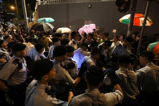 Policemen face protesters during a demonstration in the northwestern district of Tuen Mun, near the border with the Chinese city of Shenzhen, sparked by anger over provocative “dancing aunties” who have long vexed local residents. Photo via AFP.