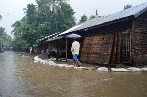 A Rohingya Muslim man walks beside a flooded road to a mosque for a Friday prayer at a camp in Sittwe located in Rakhine on June 10, 2016. – While Myanmar’s Muslim minority in Yangon freely marks the first Friday prayers on June 10, during Islam’s holy fasting month of Ramadan, the persecuted Muslim minority Rohingya in the western state of Rakhine languish in displacement camps following bloody sectarian violence in 2012 between the Rohingya and Buddhist population. Across the Muslim world, the faithful fast from dawn to dusk and strive to be more pious during the holy month, which ends with the Eid holiday. (Photo by WIN MOE / AFP)