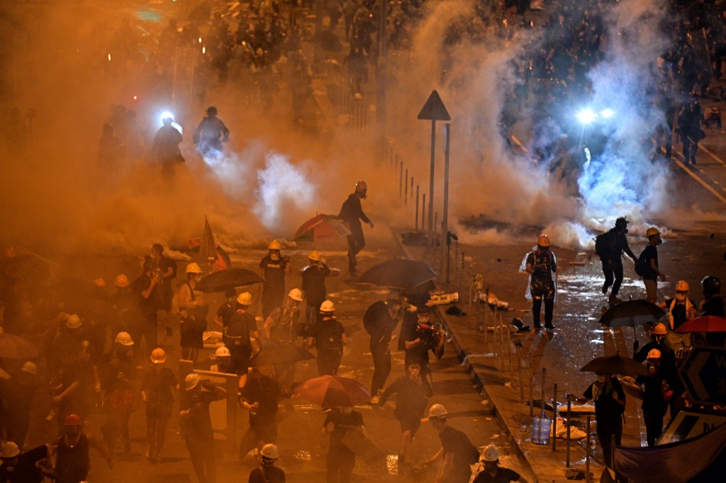 Police fire tear gas at protesters near the government headquarters in Hong Kong in the early hours of Tuesday. Photo via AFP.