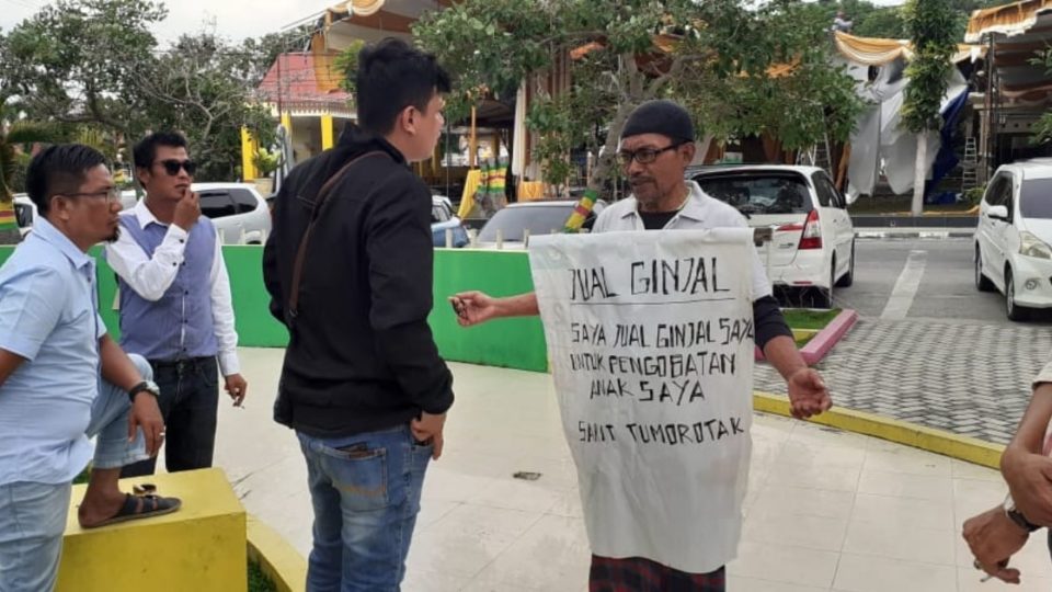 A photo of 59-year-old Eli Kristanto, a security guard whose 23-year-old son is suffering from a brain tumor.
He is wearing a sign that says “Kidney for sale. I am selling my kidney for the treatment of my child’s brain tumor.” Photo: Social Media
