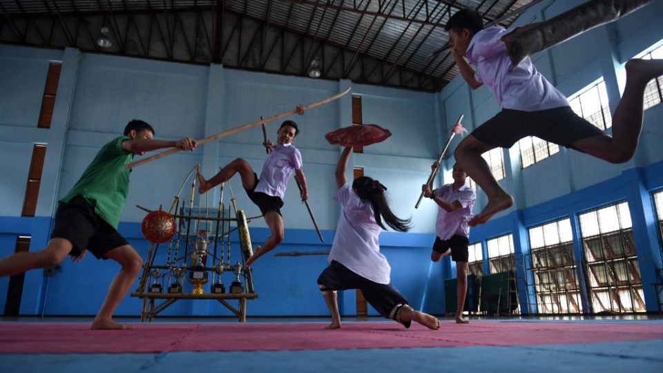 This photo taken on July 8, 2019 shows students practising Krabi Krabong, a Thai martial art, at the Thonburee Woratapeepalarak school in Thonburi, on the outskirts of Bangkok. – Armed with a wooden knife and shield, a teenage girl fends off four sword-wielding boys with high-flying kicks in an action-packed homage to Thailand’s neglected swordfighting tradition. (Photo by Lillian SUWANRUMPHA / AFP)