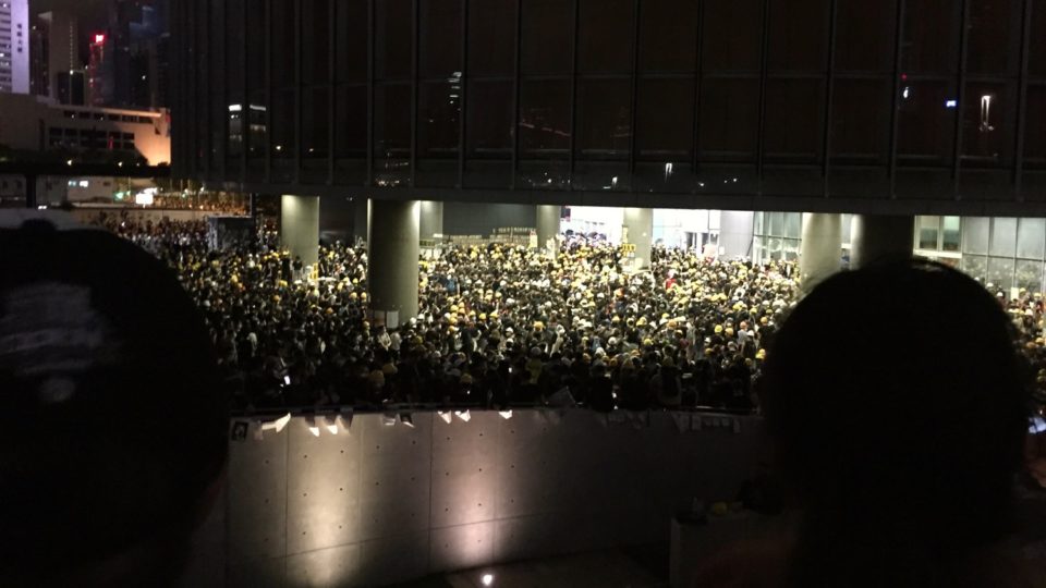 A crowd of protesters waits outside of the Legislative Council on July 1 after demonstrators forced their way into the building. Photo by Stuart White.