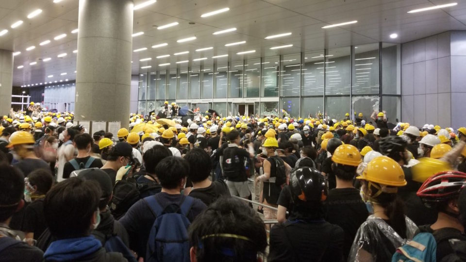 Protesters smash through the glass of the public entrance to the LegCo on July 1. Photo by Vicky Wong.