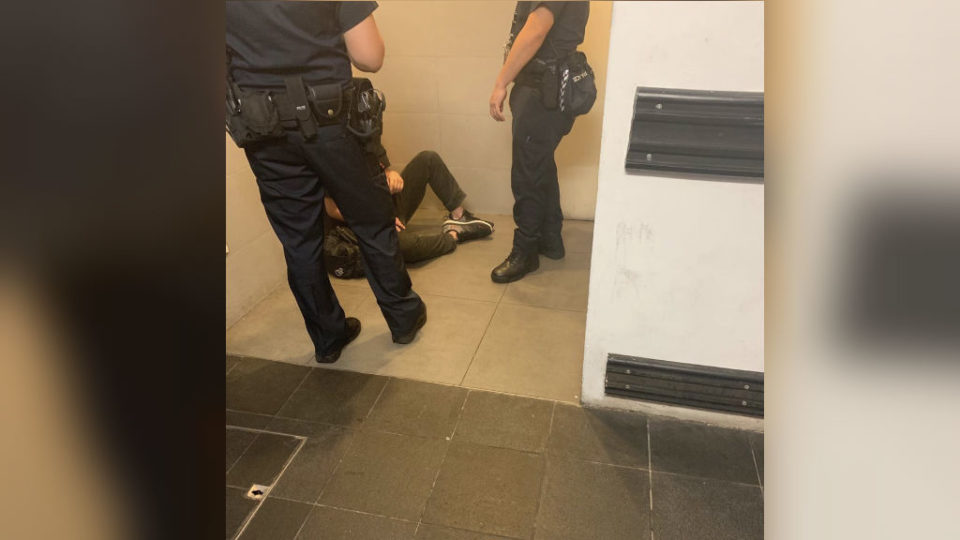 Alleged Peeping Tom with two police officers in Clarke Quay. (Photo: Instagram/Isabelle Amelia Tan)