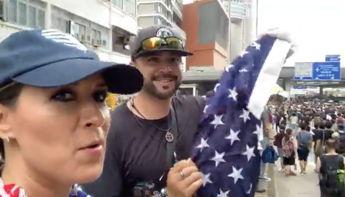 Controversial American political activist Joey Gibson, founder of the group Patriot Prayer, holds up an American flag while attending an anti-extradition rally in Hong Kong on July 7, 2019. Facebook Live screengrab