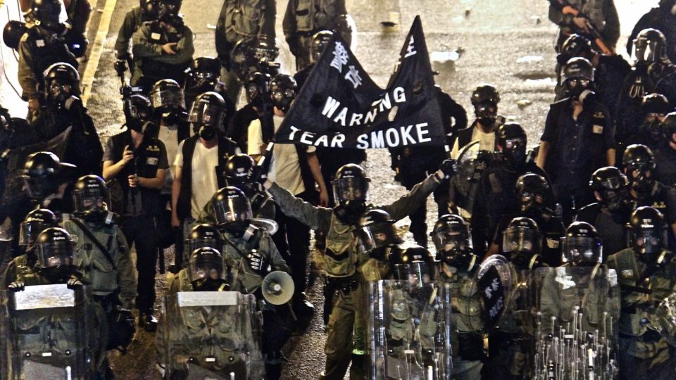 Police stationed outside Western Market in Sheung Wan hold up a black flag warning protesters they will fire tear gas unless they disperse on July 21, 2019. Photo by Vicky Wong.
