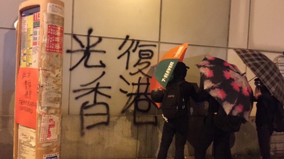 Protesters spray paint graffiti on the wall of the liaison office, the headquarters of the Chinese central government in Hong Kong. Photo by Stuart White.