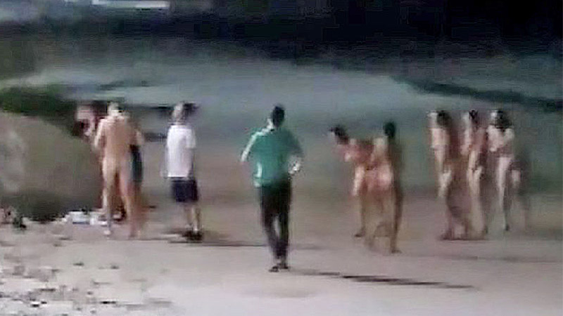 Six skinny dippers walk back to their pile of clothes on in Krabi’s Ao Nang beach to get dressed. Image: Viral Press  