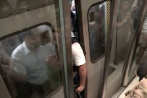 Man sticks his arm in train door at Tiu King Leng MTR station. Screengrab via Facebook/RTHK.