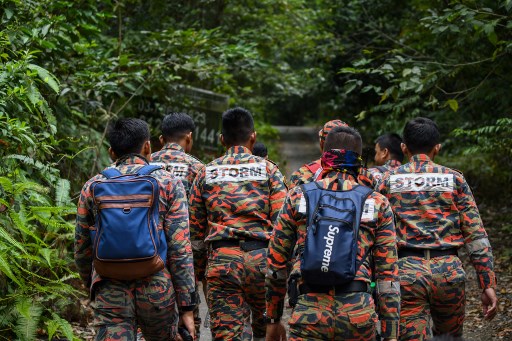 Members of Malaysian rescue team take part in a search and rescue operation for the missing 15-year-old Franco-Irish, Nora Quoirin in Seremban on August 7, 2019. - A helicopter and dozens of people were deployed August 7 on the third day of a search for a vulnerable London teenager who went missing from a Malaysian rainforest resort, police said. (Photo by Mohd RASFAN / AFP)