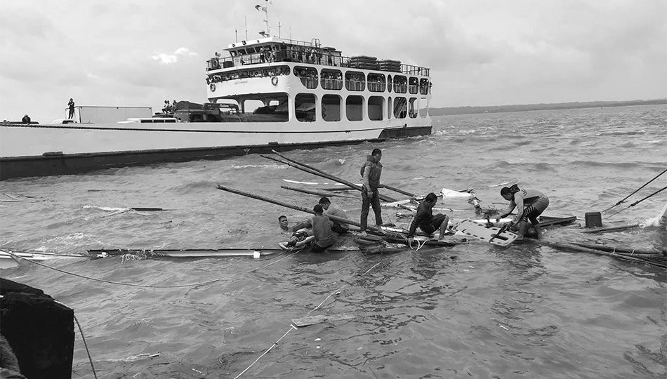 Rescuers search for dead bodies underneath one of the capsized boats at the Iloilo-Guimaras Strait. Photo: ABS-CBN News.