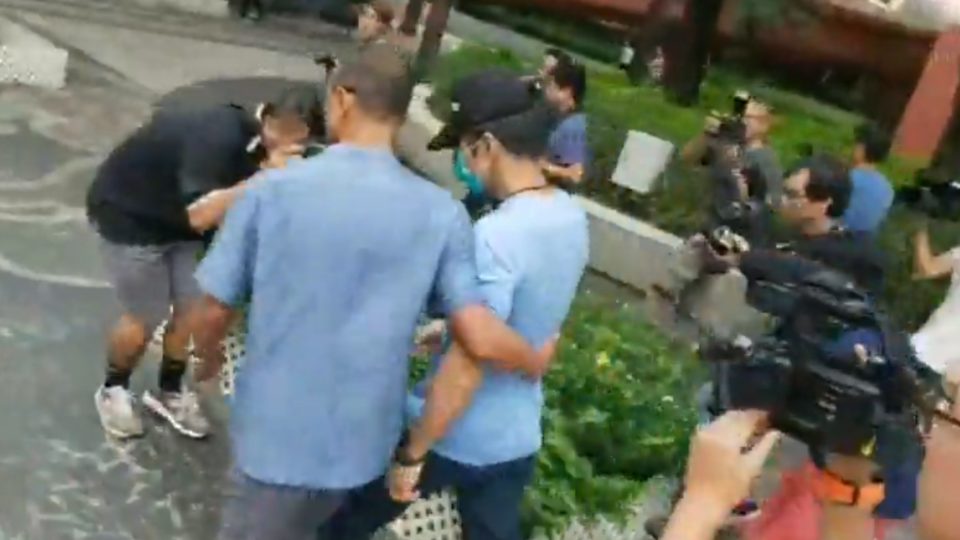 One of the suspects in the assault of an elderly man by two police officers is hounded by press after leaving the Shatin Magistrates’ Court today. Screengrab via Facebook/Stand News.