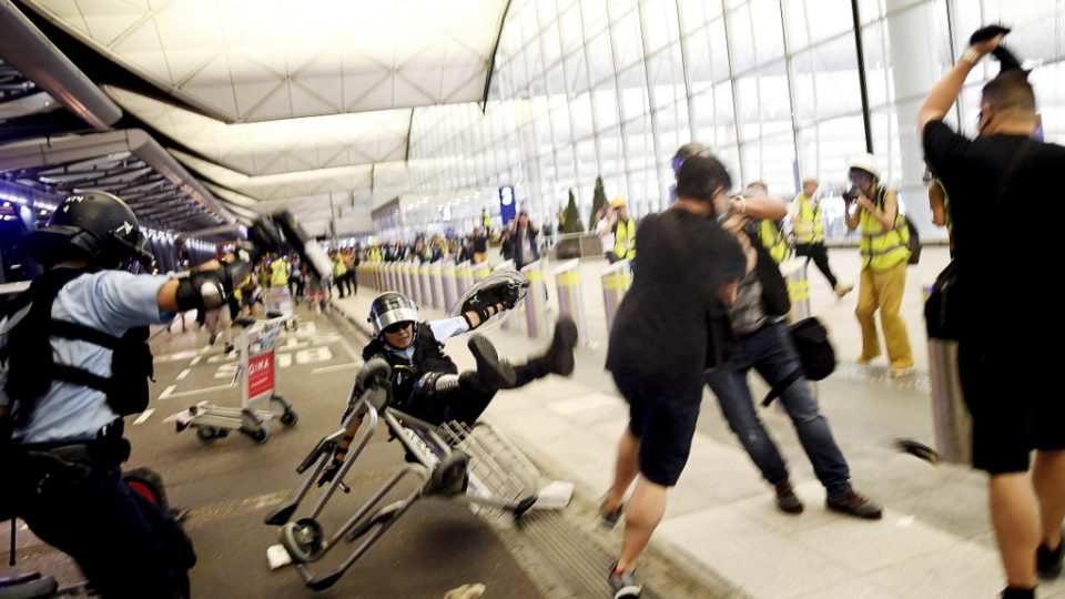 Police scuffle with pro-democracy protesters at Hong Kong International Airport last night. Photo via AFP.