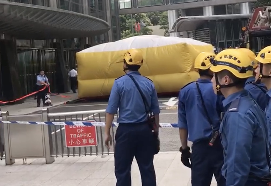 Authorities at the scene of a stunt in which a man scaled the Cheung Kong Center this morning. Photo by Chad Williams.