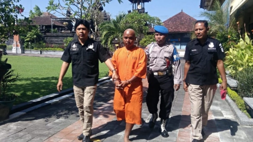 Muhammad Toha, wearing the prison uniform, was escorted by police officers to jail after a press conference in April. Photo: Denpasar Police Deputy Chief Benny Pramono