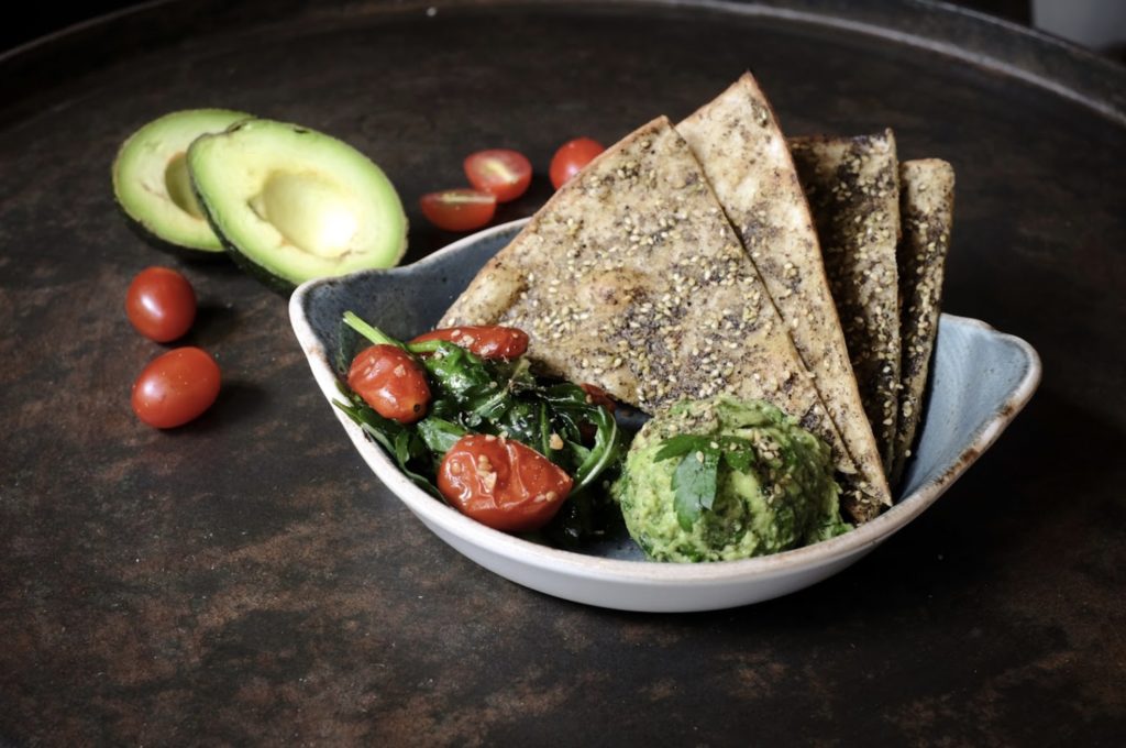 Mashed and chunky guacamole, greens & our classic flatbread sprinkled with zaatar from Mana! Photo via Facebook/Mana!