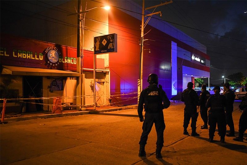 Policemen stand outside the Caballo Blanco bar in Coatzacoalcos, Mexico  where 28 people were killed. <i>Photo: Victoria Razo/AFP</i>
