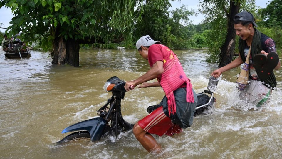 Men push their motorcycle through floodwaters in Shwegyin township, Bago Region on August 8, 2019. Photo by Ye Aung Yhu / AFP