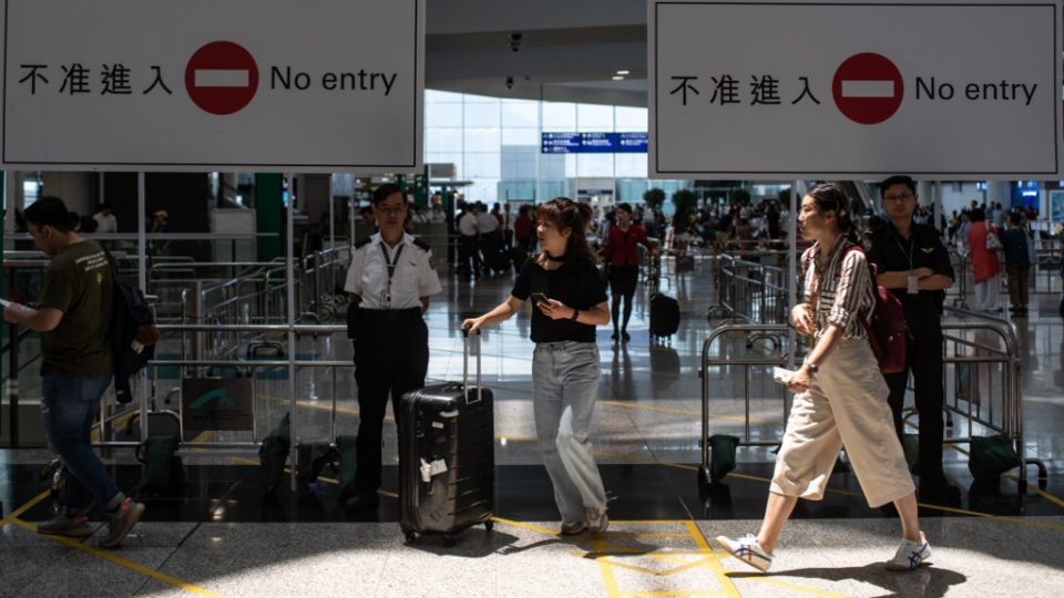 Passengers walk past the arrivals hall of Hong Kong International Airport today after a night of chaos that has prompted reflection in the protesters’ camp. Photo via AFP.