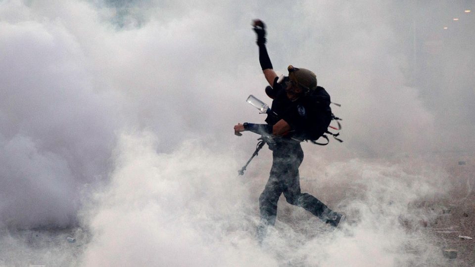 A protester throws bricks at the police after they fired tear gas in Wong Tai Sin during a general strike in Hong Kong on August 5, 2019, as simultaneous rallies were held across seven districts. Photo by Isaac Lawrence / AFP