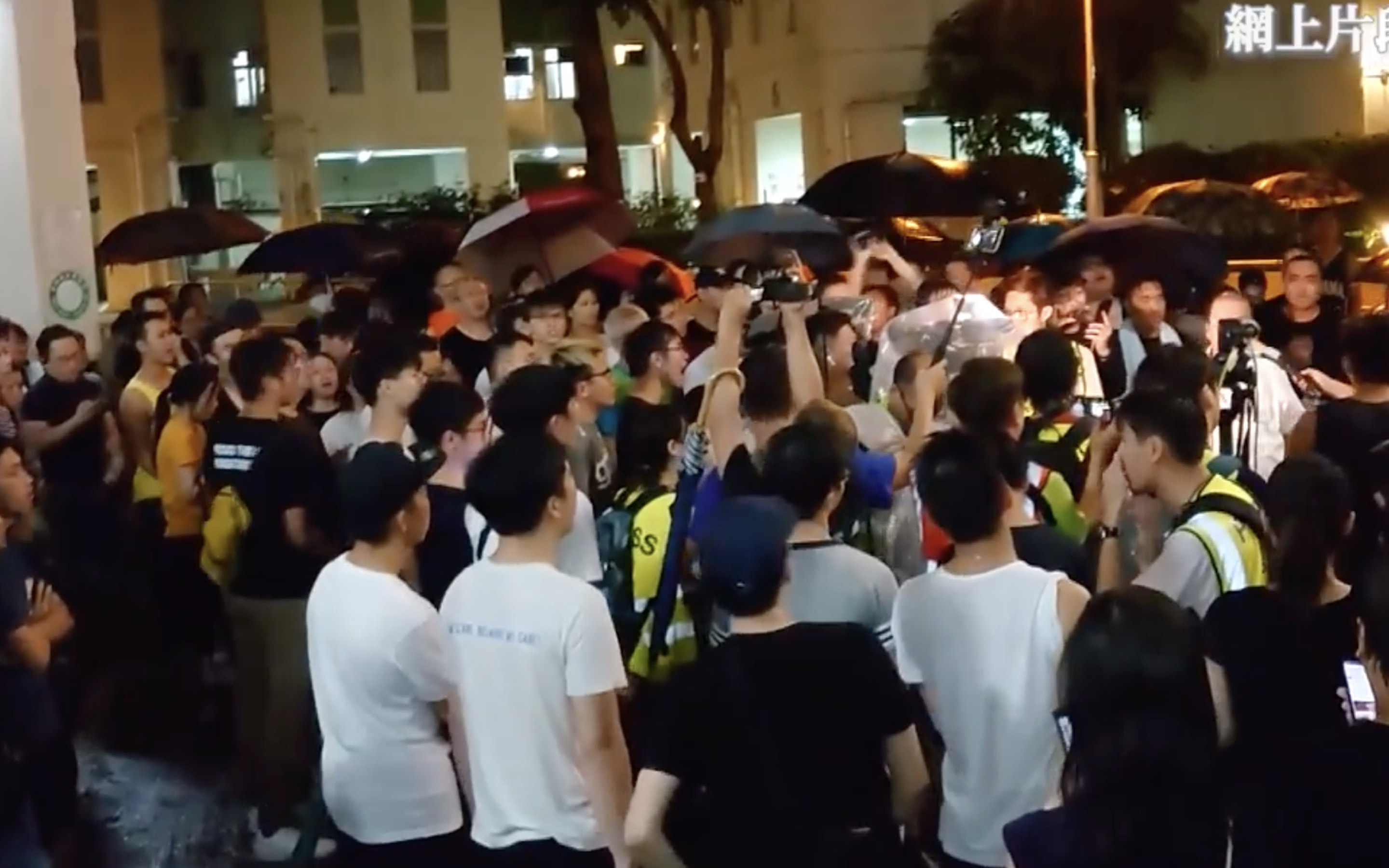 Dozens of angry residents from the Richland Gardens surround the housing estate’s management office after it emerged that  the door codes for all the buildings had been changed and that the estate’s security were blocking people in black shirts from entering. Screengrab via Facebook/RTHK.