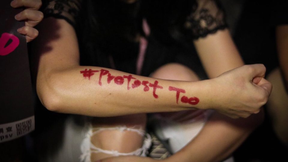 A protester with the phrase “#ProtestToo” written on her arm in lipstick at a rally against the alleged sexual harassment of female protesters by police. Photo by Samantha Mei Topp.