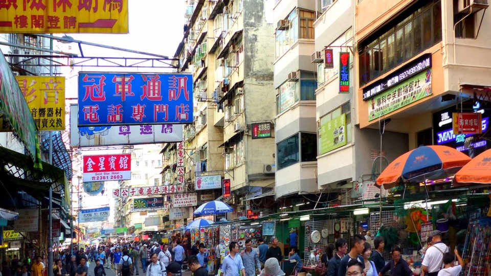 Pedestrians on a shopping street in Sham Shui Po, where someone rained anti-protester fliers onto the street from a nearby building last night. Photo via Flickr/Bernard Spragg.