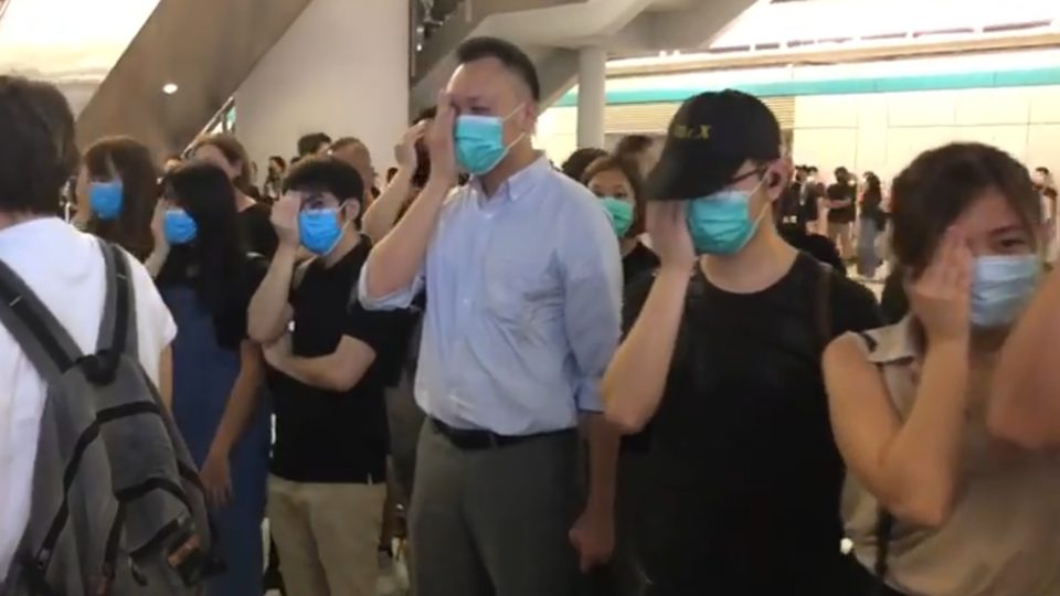 Protesters gathered at Yuen Long MTR to voice their disappointment in police cover their right eyes in reference to a woman who was believed to have been shot in the eye with a police bean bag round. Screengrab via Facebook/Stand News.