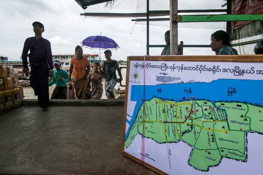 This photograph taken August 1, 2019 shows people from Dala township arriving by boat in Yangon after crossing the Yangon River. – From her scruffy, downtrodden bank of the river, teashop-owner Khin looks a few hundred metres across the muddy water to Yangon and dreams of the riches promised by a new bridge linking to Myanmar’s commercial heart. (Photo by Sai Aung MAIN / AFP)