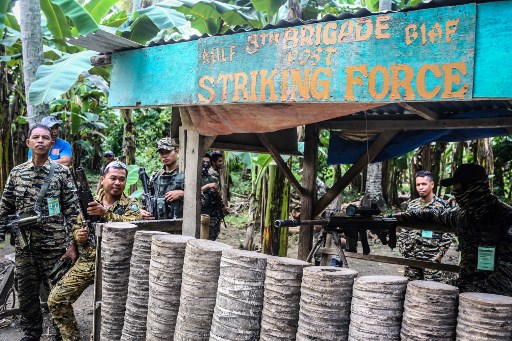 Moro Islamic Liberation Front (MILF) rebels stand guard at the entry of Camp Darapanan, Sultan Kudarat town on the southern Philippine island of Mindanao on September 7, 2019 ahead of a weapons decommissioning ceremony. (Photo by Ferdinandh CABRERA / AFP)