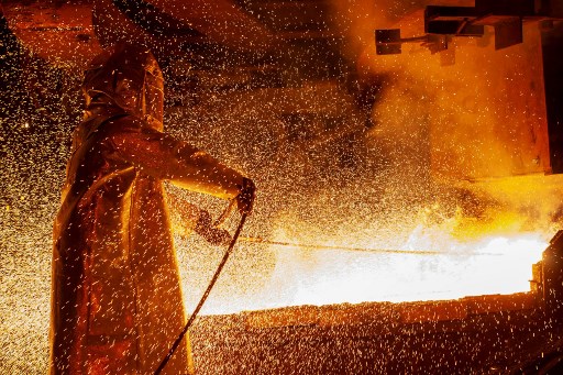 This picture taken on March 30, 2019 shows a worker manning a furnace during the nickel smelting process at Indonesian mining company PT Vale’s smelting plant in Soroako, South Sulawesi. (Photo by Bannu MAZANDRA / AFP)
