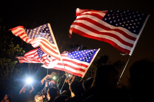 Pro-democracy activists hold US flags while forming a human chain on Lion Rock in Hong Kong on September 13, 2019. – Thousands of Hong Kong pro-democracy activists used torches, lanterns and laser pens to light up two of the city’s best-known hillsides on September 13 night in an eye-catching protest alongside an annual festival. The evening of September 13 marks the start of the mid-autumn festival, one of the most important dates in the Chinese calendar, and is traditionally a time for thanksgiving, spending time with family and praying for good fortune. (Photo by Anthony WALLACE / AFP)