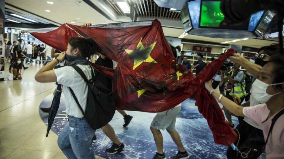 Pro-democracy protesters desecrate the Chinese national flag during a protest at the New Town Plaza shopping mall in Hong Kong’s Sha Tin district on September 22, 2019. – The demonstrators rallied inside a mall on September 22, with some activists vandalising a nearby subway station and defacing a Chinese flag, but plans to disrupt the airport did not materialise. (Photo by Isaac LAWRENCE / AFP)