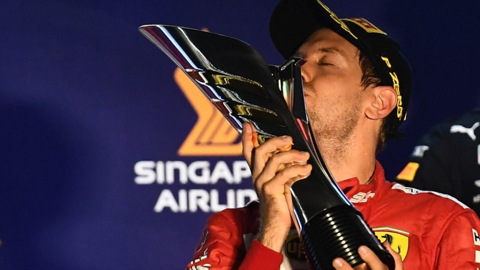 Ferrari’s German driver Sebastian Vettel kisses the trophy on the podium after winning the Formula One Singapore Grand Prix night race at the Marina Bay Street Circuit in Singapore on September 22, 2019. (Photo by Mohd RASFAN / AFP)