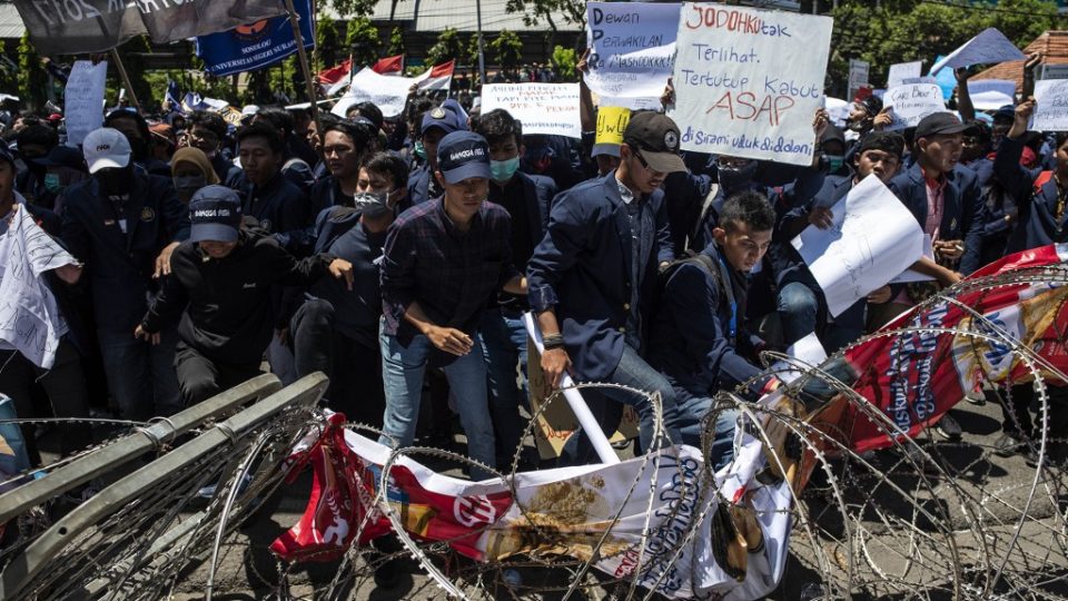 Student protesters step on barbed wire during a rally in Surabaya, East java province, on September 25, 2019, against the government’s proposed change in its criminal code laws and plans to weaken the anti-corruption commission. (Photo by JUNI KRISWANTO / AFP)