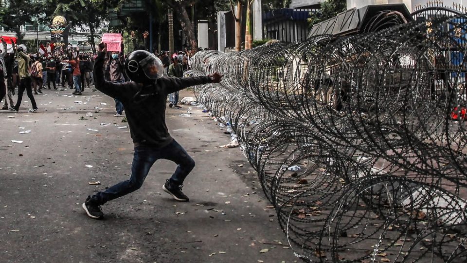 An Indonesian student throws a rock to the police during a rally against divisive legal reforms, in front of a parliament building in Medan, North Sumatra, on September 27, 2019. – A second Indonesian student protester died from injuries sustained during a wave of nationwide demonstrations against divisive legal reforms, including banning pre-marital sex and weakening the anti-graft agency, officials said. (Photo by ALBERT IVAN DAMANIK / AFP)