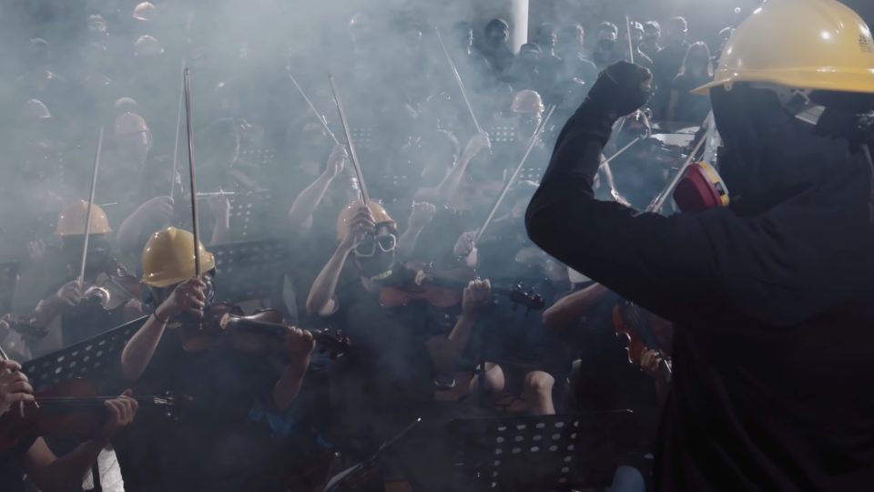 An orchestra and choir dressed in full protest gear perform in a music video for “Glory to Hong Kong,” a new anthem created for the protest movement. Screengrab via YouTube