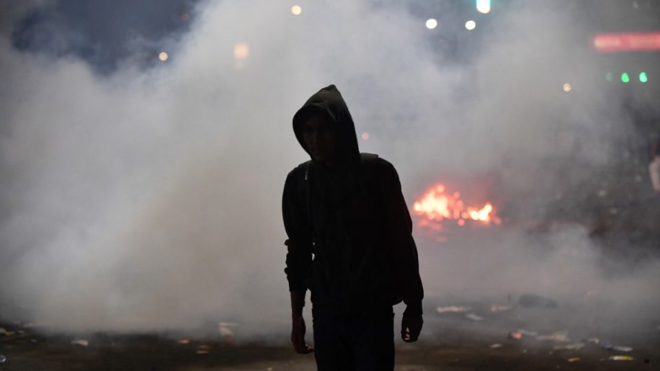 An Indonesian student stands amidst tear gas fired by police during a protest outside the parliament building in Jakarta on September 30, 2019. (Photo by ADEK BERRY / AFP)