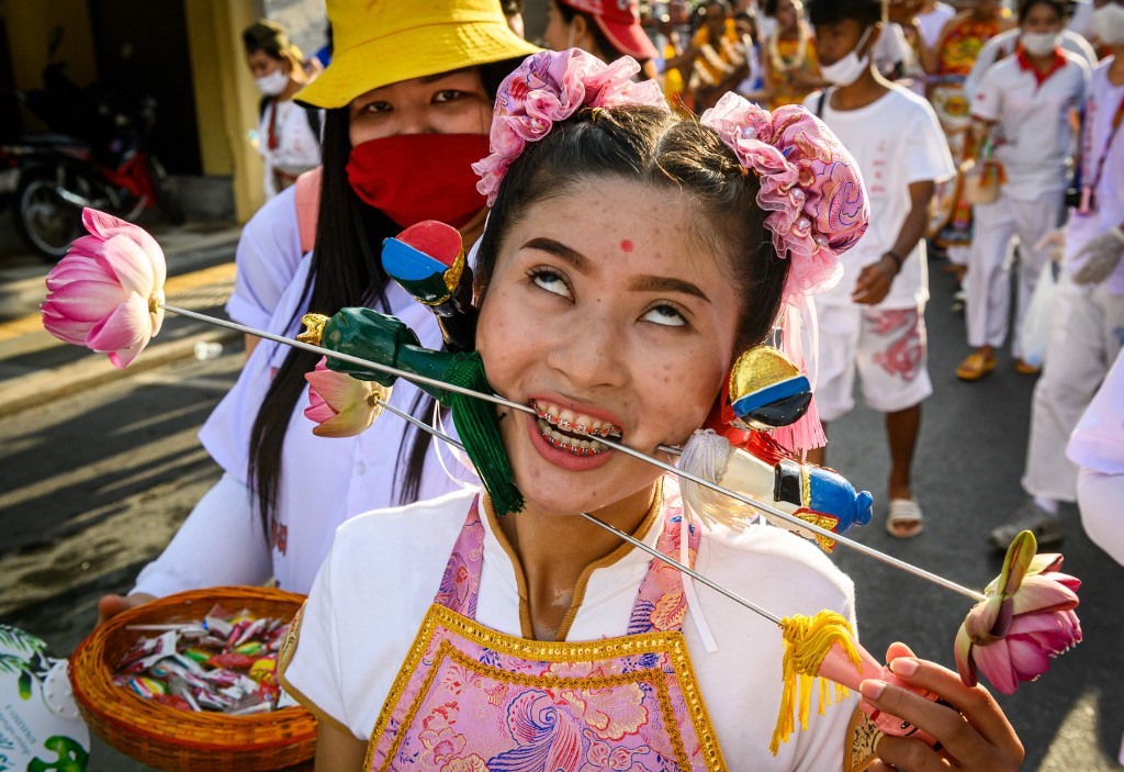 A devotee of a Chinese shrine with skewers pierced through her cheeks takes part in a procession during the annual Vegetarian Festival in Phuket on October 3, 2019. Photo: Mladen Antonov / AFP