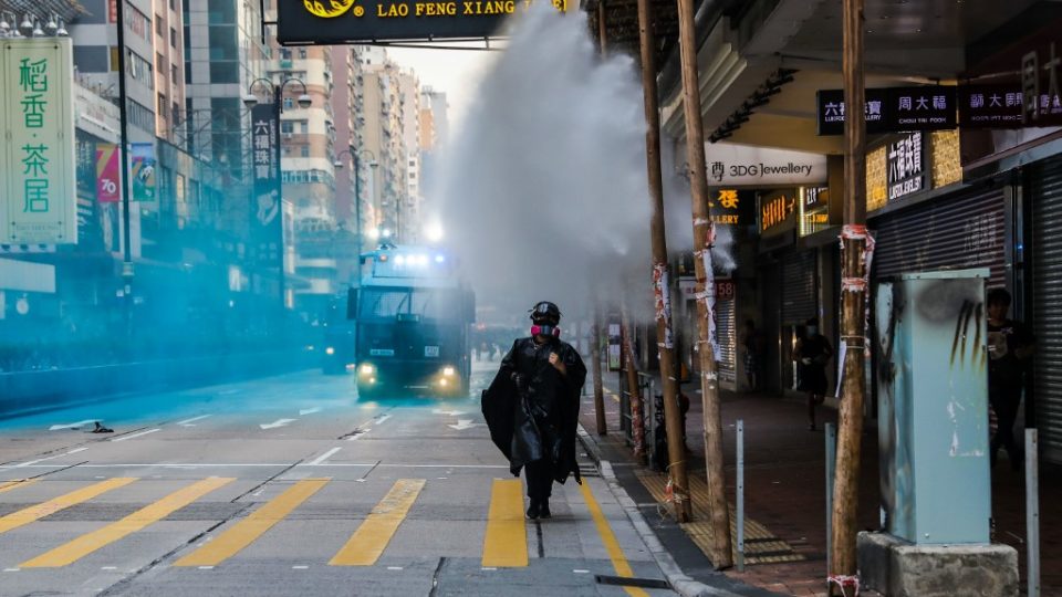 A protester runs from advancing police as they deploy a water cannon on a road in the Tsim Sha Tsui district in Hong Kong on October 20, 2019. – Police fired water cannon and tear gas at Hong Kongers who defied authorities with an illegal march on October 20, their numbers swollen by anger over the recent stabbing and beating of two pro-democracy protesters. (Photo by DALE DE LA REY / AFP)