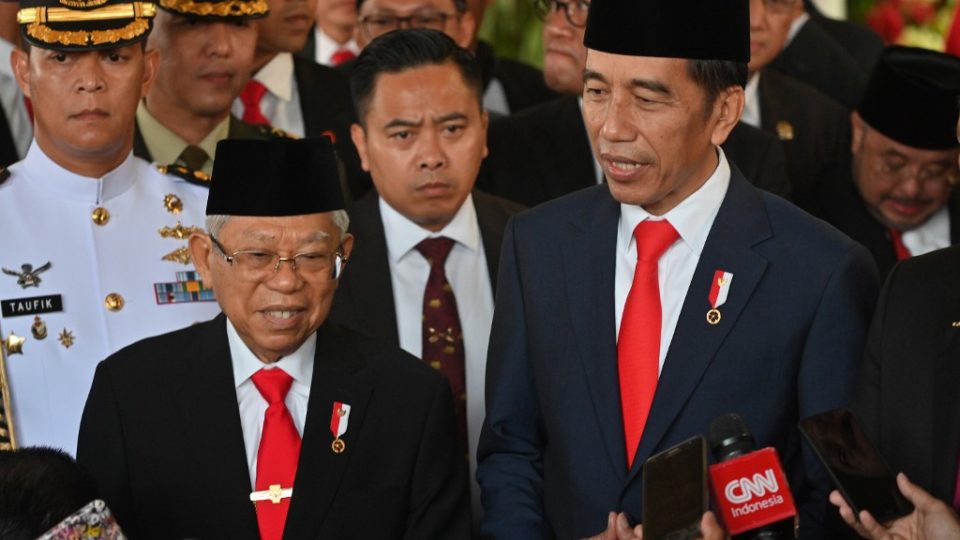 Indonesian President Joko Widodo (R) speaks to journalists with new Vice President Ma’ruf Amin (L) after their inauguration at the parliament building in Jakarta on October 20, 2019. – Indonesia’s President Joko Widodo was sworn in for a second term on October 20, as helicopters flew overhead and troops kept watch in the capital Jakarta — days after Islamist militants tried to assassinate his top security minister. (Photo by ADEK BERRY / POOL / AFP)